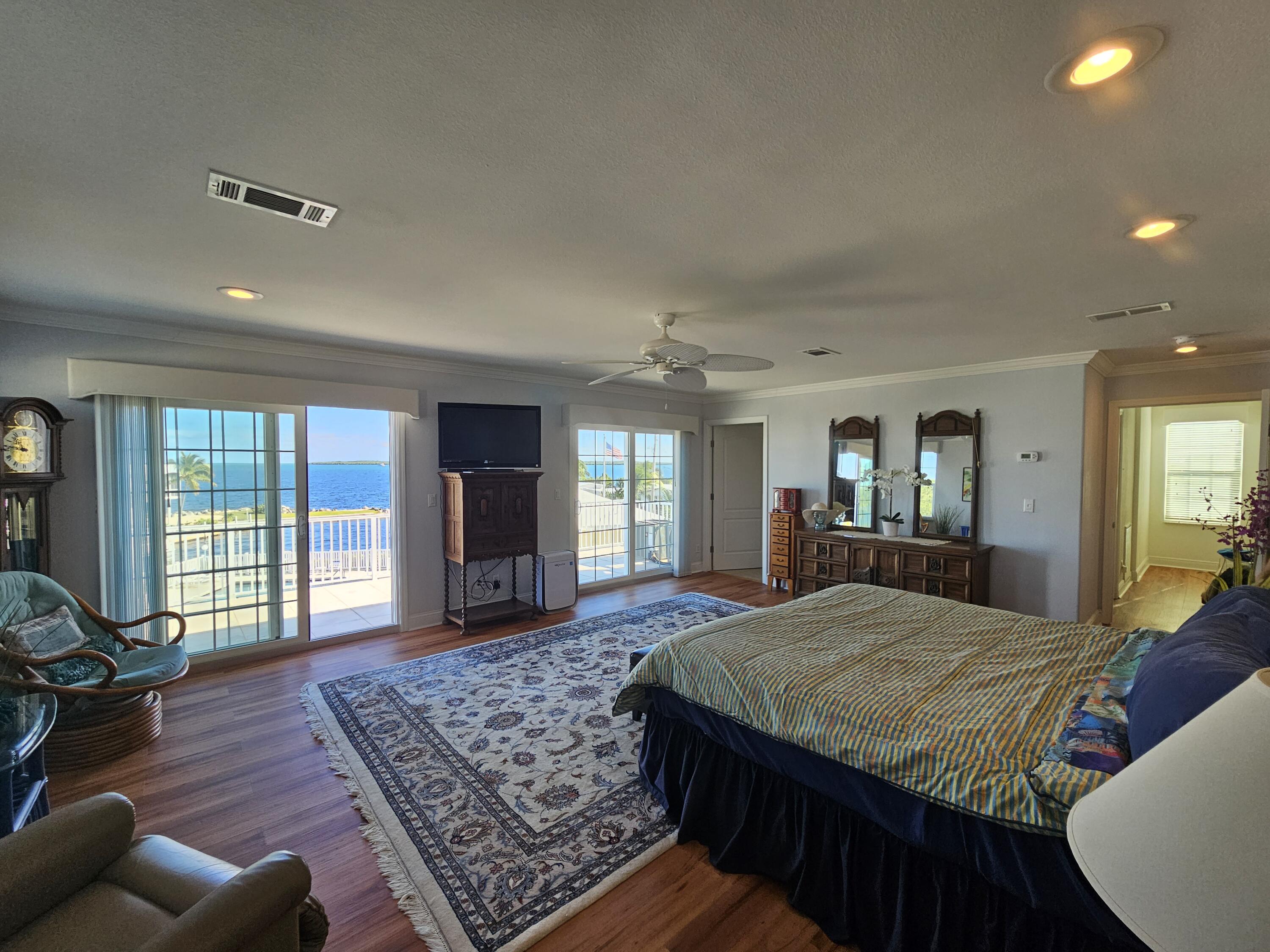 55 Ocean Drive Key Largo, FL 33037 - Photo 27 of 53 a large bedroom with wooden floor and large window
