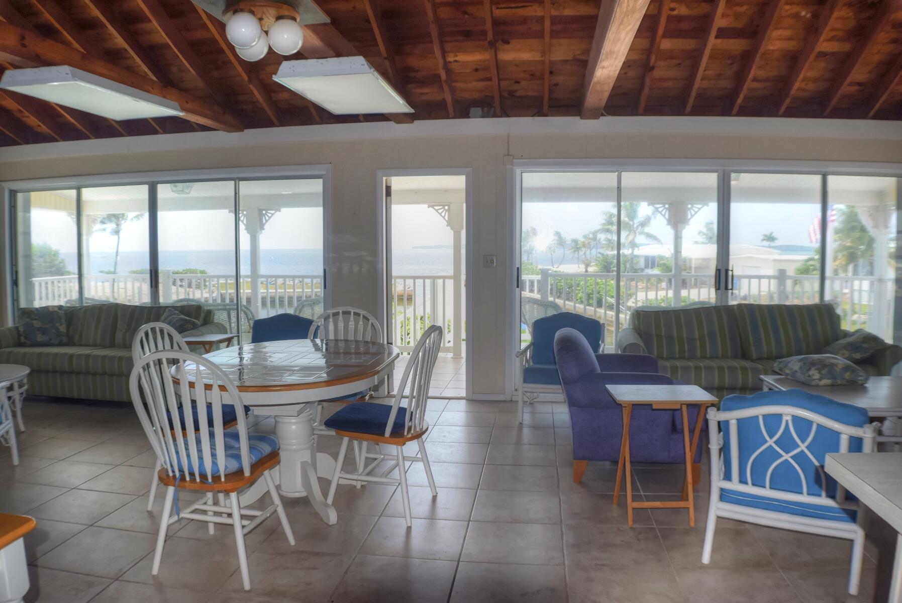 55 Ocean Drive Key Largo, FL 33037 - Photo 48 of 53 a view of a dining room with furniture large windows and wooden floor