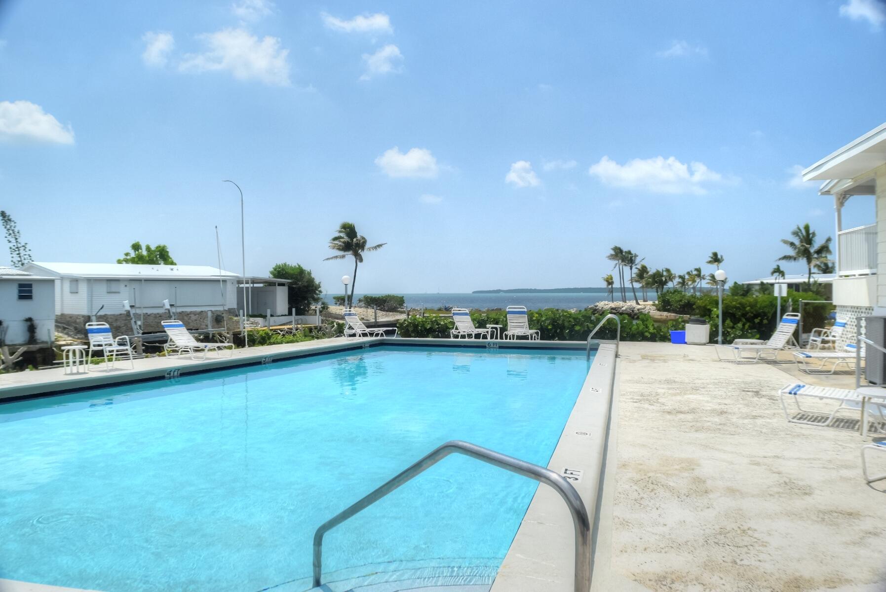 55 Ocean Drive Key Largo, FL 33037 - Photo 50 of 53 a view of a swimming pool and a chairs