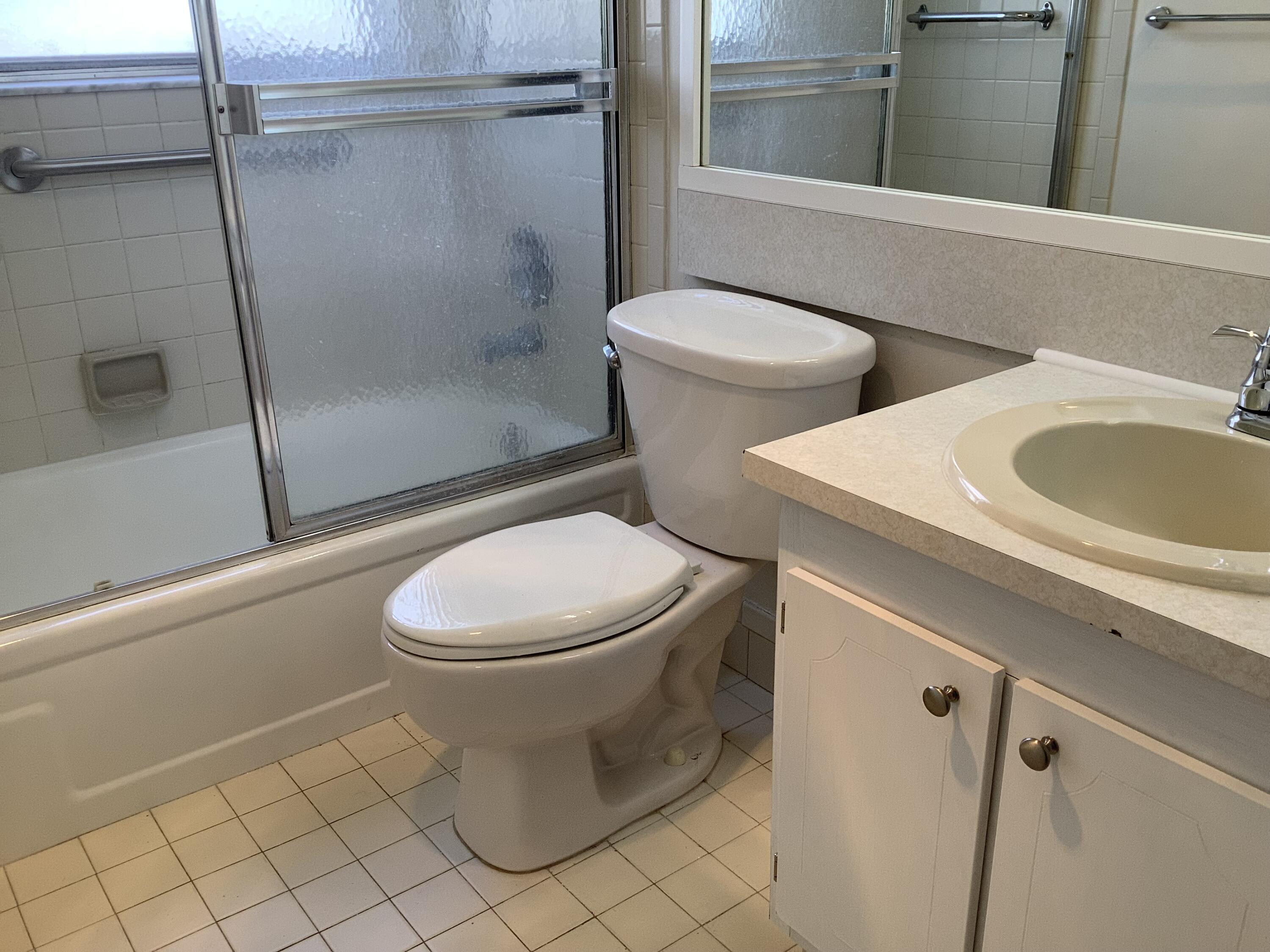 560 Fanshaw North, Unit 560 Boca Raton, FL 33434 - Photo 13 of 26 a white toilet sitting next to a bath tub