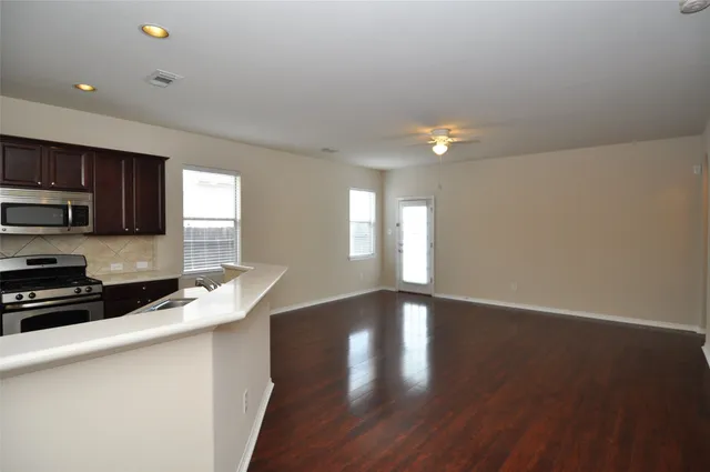 a kitchen with granite countertop a stove a sink and a microwave