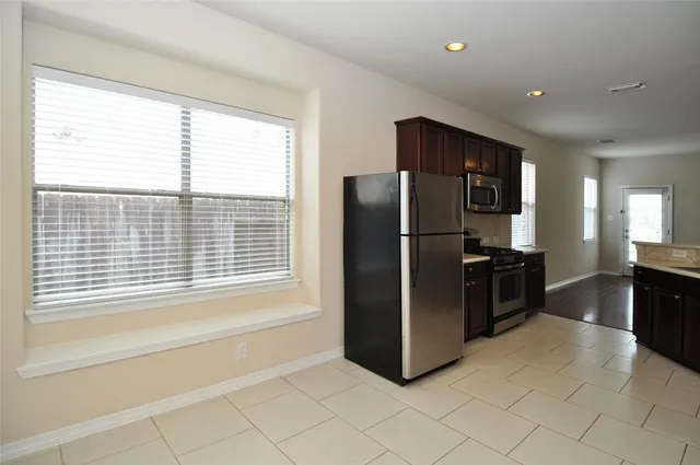 a kitchen with a refrigerator and a stove top oven