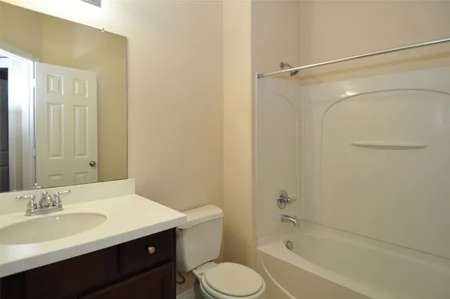 a bathroom with a sink toilet vanity and shower