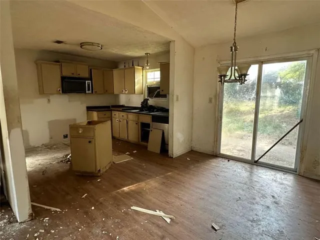 a view of a kitchen with fridge and wooden floor