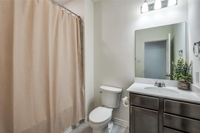 a bathroom with a sink a toilet and shower curtain