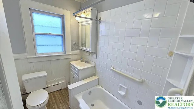a bathroom with a toilet a sink a bath tub and mirror