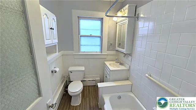 a bathroom with a toilet a sink and mirror