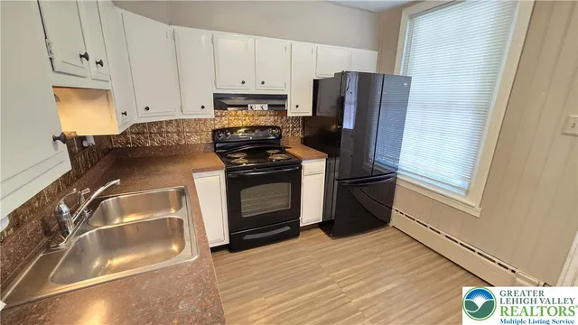 a kitchen with a refrigerator stove and wooden cabinets
