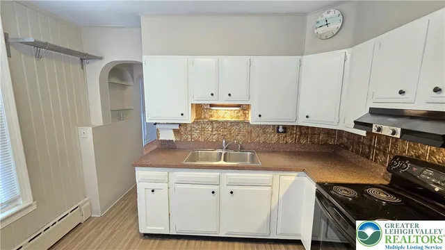 a kitchen with granite countertop a sink a stove and cabinets
