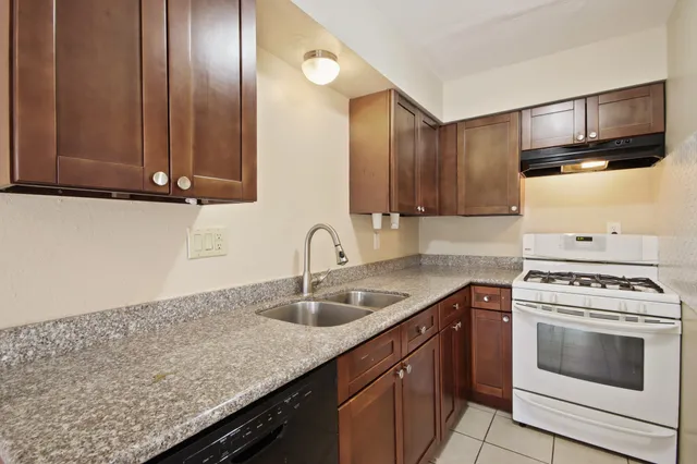a kitchen with granite countertop cabinets stainless steel appliances and wooden floor