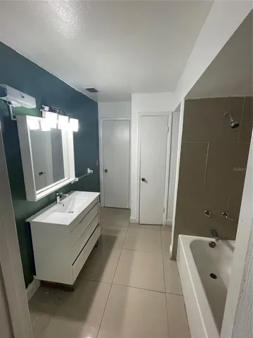 a bathroom with a tub sink and mirror