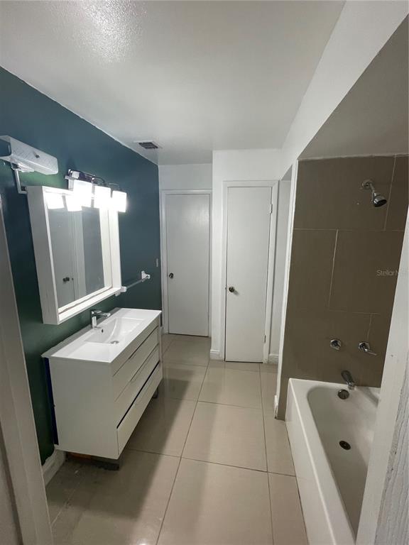 7352 Balboa Drive, Unit 7352 Orlando, FL 32818 - Photo 4 of 6 a bathroom with a tub sink and mirror