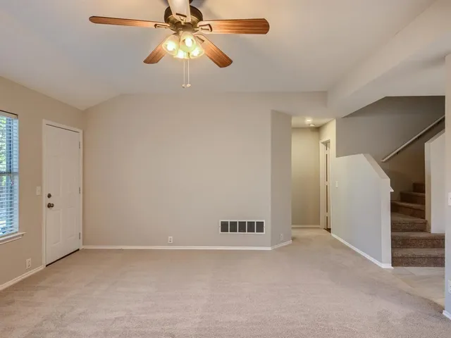 an empty room with closet and a chandelier fan