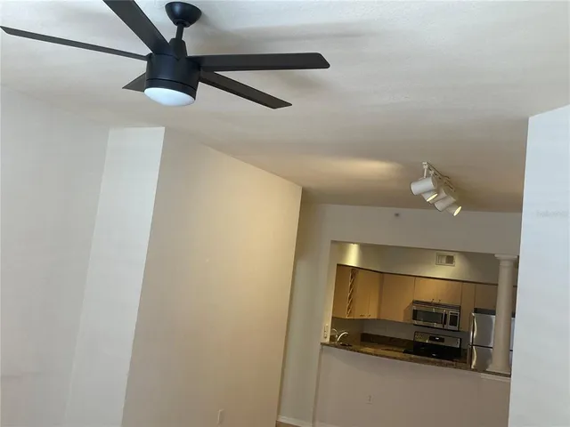 a bathroom with a refrigerator and a ceiling fan