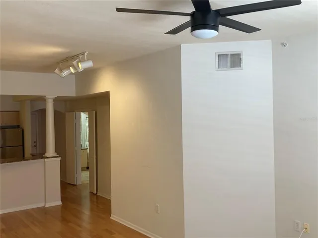 a view of a hallway with wooden floor and chandelier