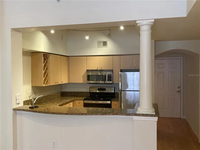 a kitchen with kitchen island a sink stainless steel appliances and cabinets