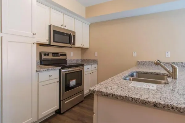 a kitchen with a sink a stove and cabinets