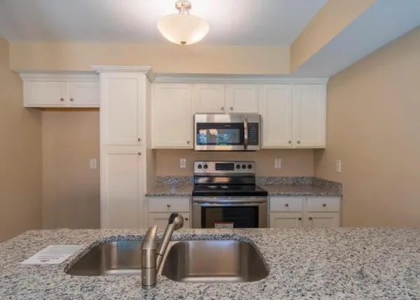 an empty room with cabinet and windows