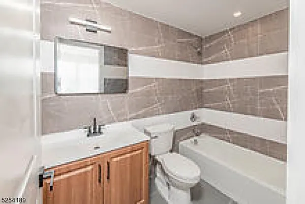 a bathroom with a bathtub shower sink vanity and toilet