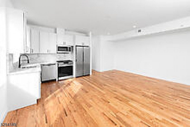 125 Broughton Avenue, Unit 2 Bloomfield, NJ 07003 - Photo 8 of 9 a kitchen with kitchen island a sink stainless steel appliances and cabinets