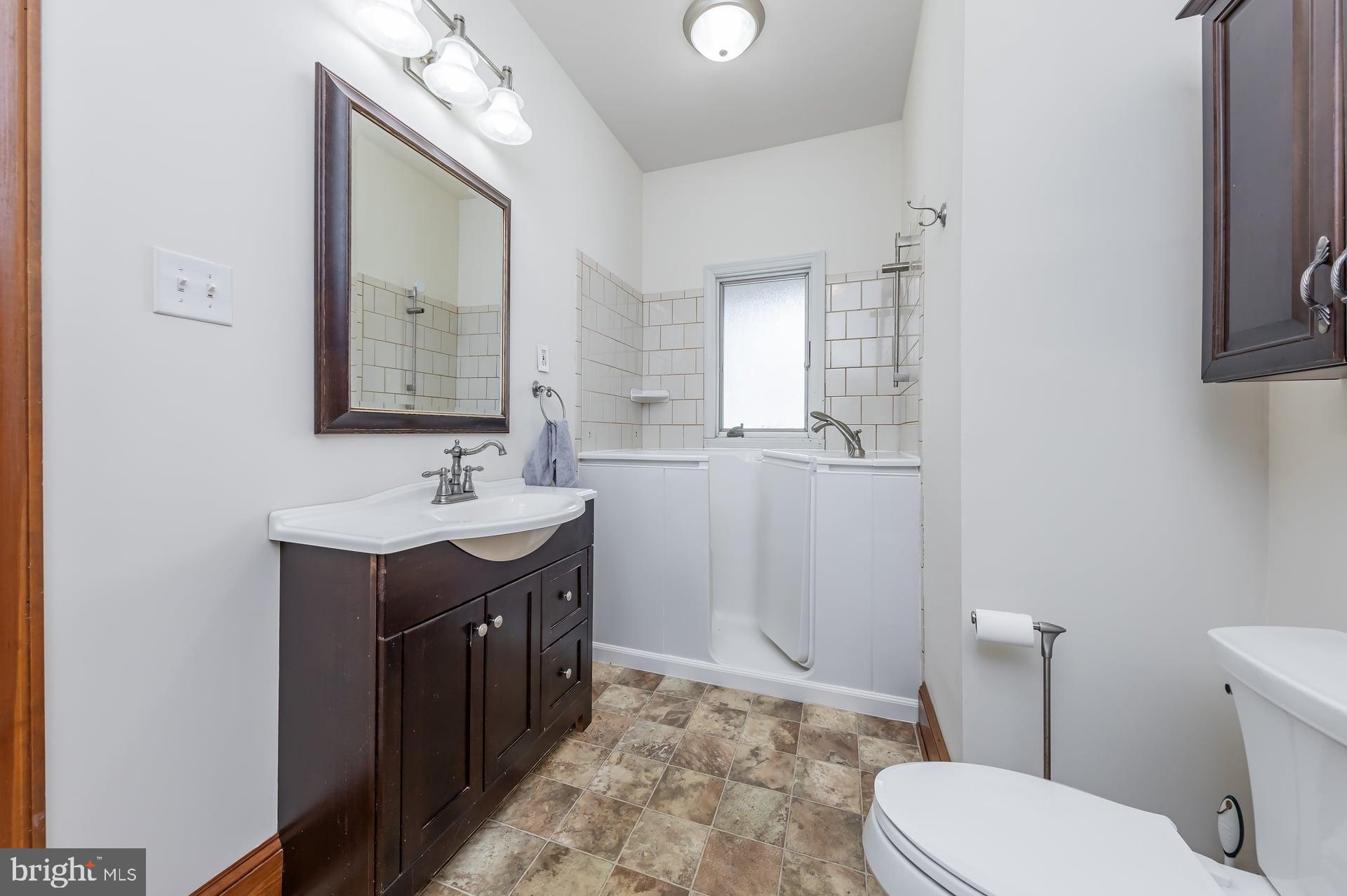 175 Queen Street West Deptford, NJ 08086 - Photo 11 of 23 a bathroom with a sink vanity mirror and toilet