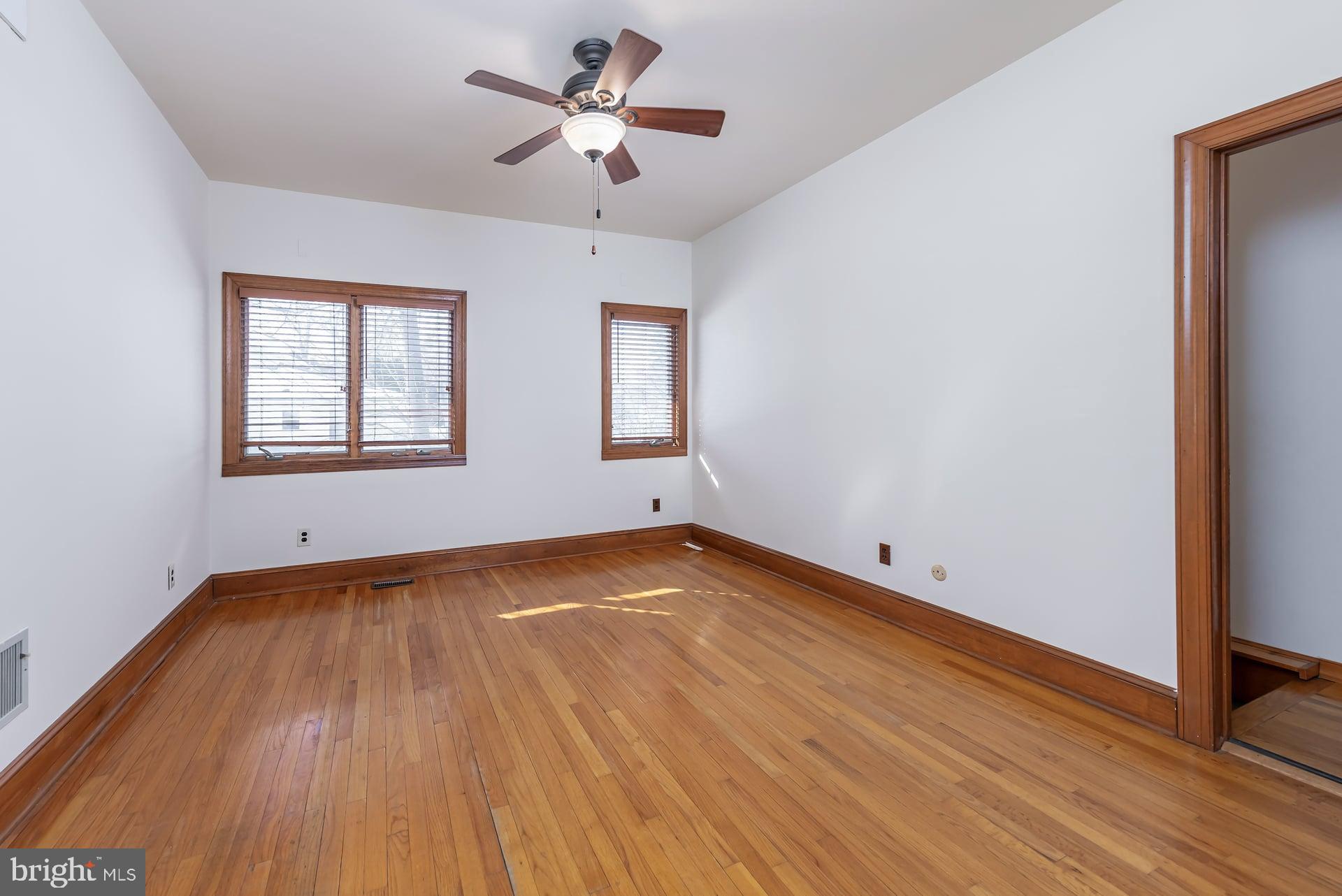 175 Queen Street West Deptford, NJ 08086 - Photo 8 of 23 an empty room with wooden floor chandelier fan and windows