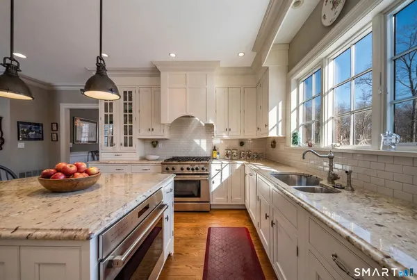 a kitchen with stainless steel appliances granite countertop a sink stove and cabinets