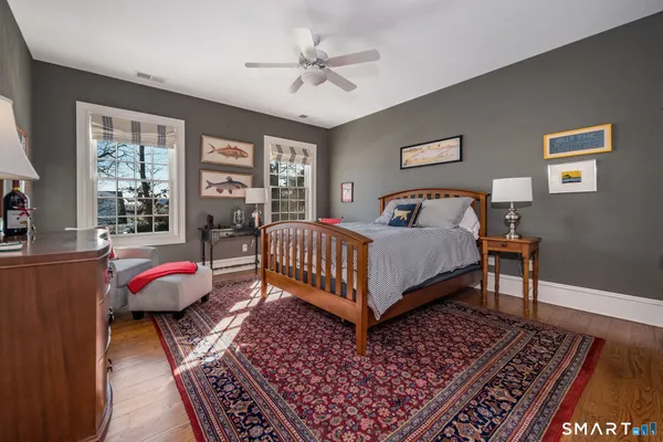 a bedroom with a large bed a chandelier and windows