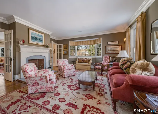 a living room with furniture fireplace and a large window