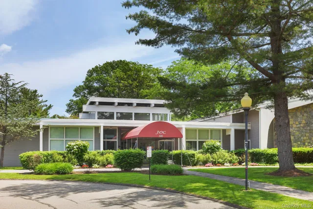 a front view of a house with a yard and potted plants
