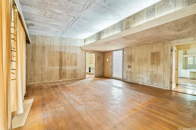 a view of an empty room with wooden floor