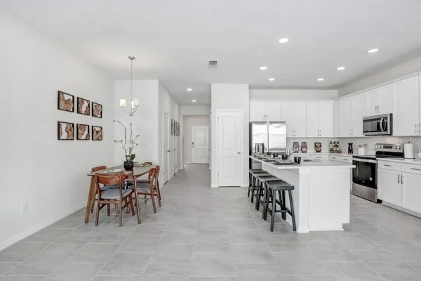 a kitchen with a sink and chairs