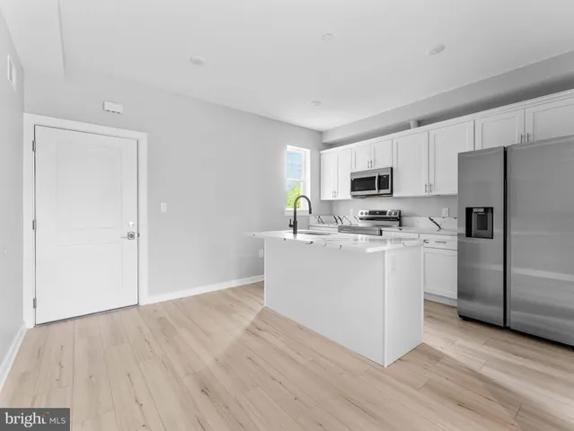 a kitchen with white cabinets and stainless steel appliances