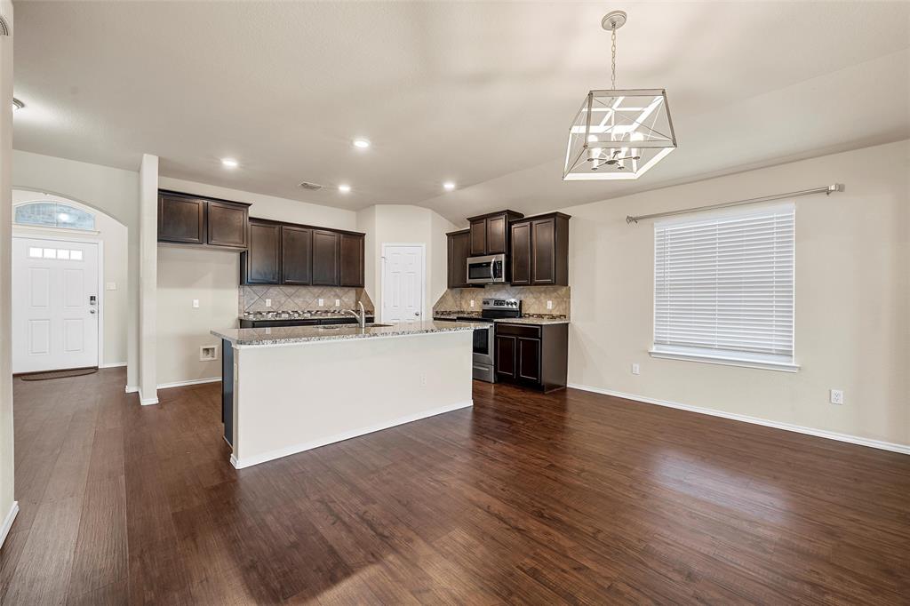 3217 Beutel Road Lorena, TX 76655 - Photo 15 of 40 Kitchen with stainless steel appliances, dark brown cabinetry, tasteful backsplash, a kitchen island with sink, and recessed lighting