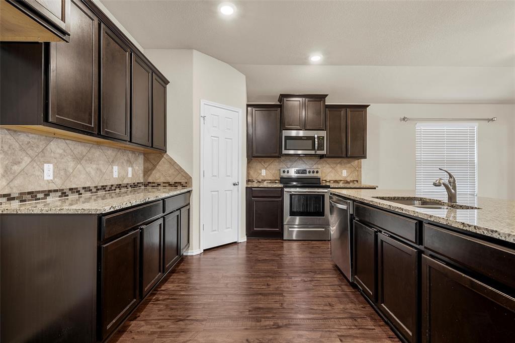 3217 Beutel Road Lorena, TX 76655 - Photo 10 of 40 Kitchen with stainless steel appliances, light stone countertops, dark brown cabinets, dark wood-type flooring, and recessed lighting