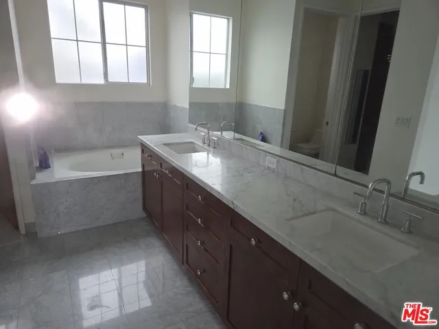 a bathroom with a granite countertop sink mirror and shower