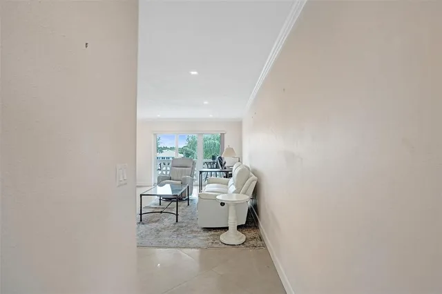 a living room with furniture white walls and kitchen view