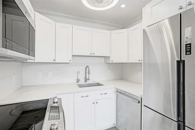 a kitchen with stainless steel appliances granite countertop white cabinets and window