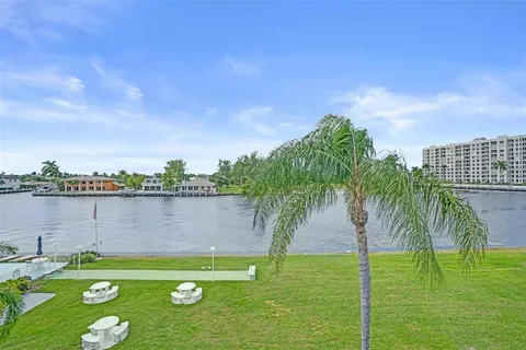 a view of a hallway with wooden floor and windows