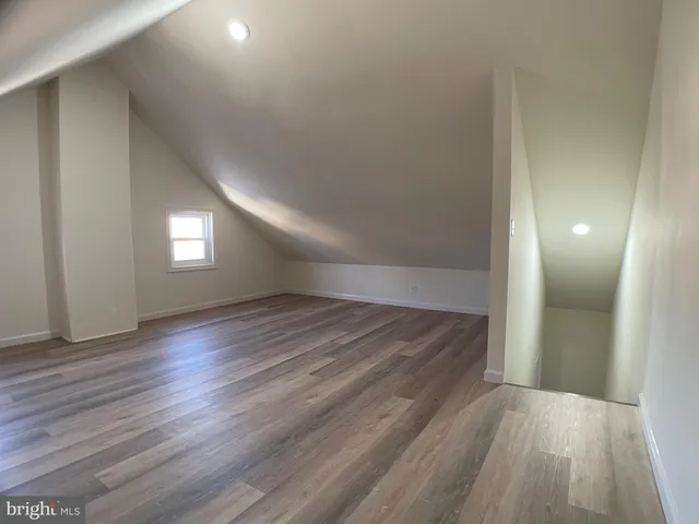 a view of empty room with window and wooden floor