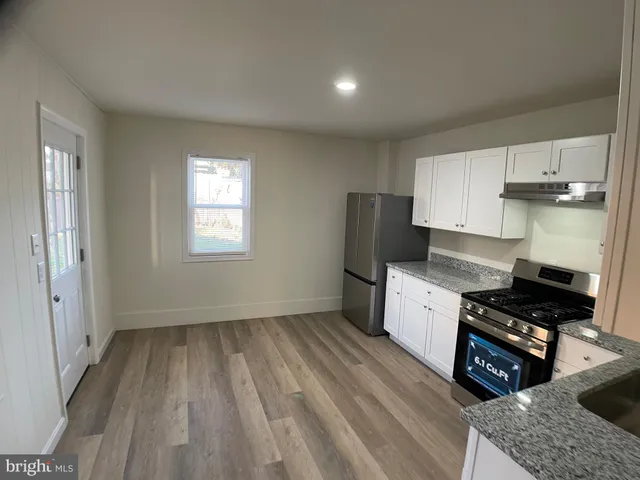 a kitchen with granite countertop a stove a sink dishwasher and a refrigerator