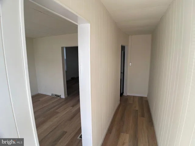 a view of a hallway with wooden floor
