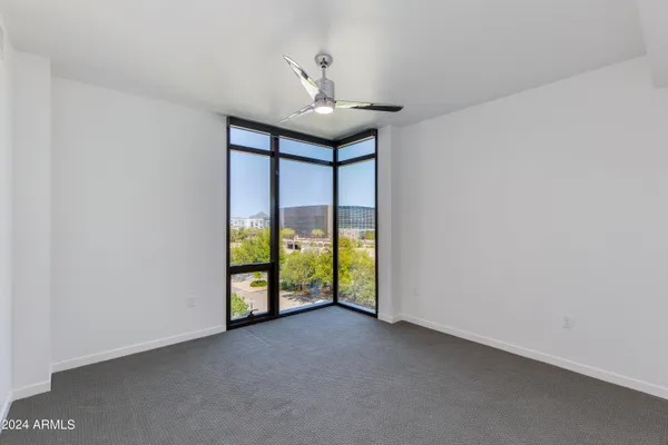 a view of an empty room with chandelier fan