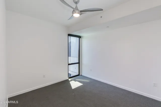 an empty room with a empty space and a ceiling fan