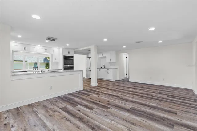 a view of a kitchen with kitchen island a sink stainless steel appliances and cabinets