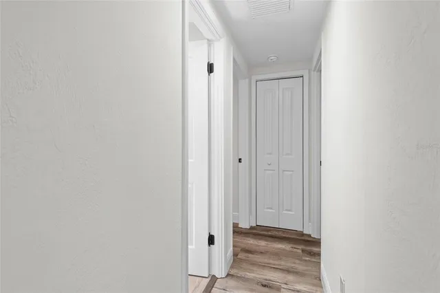a view of a hallway with wooden floor