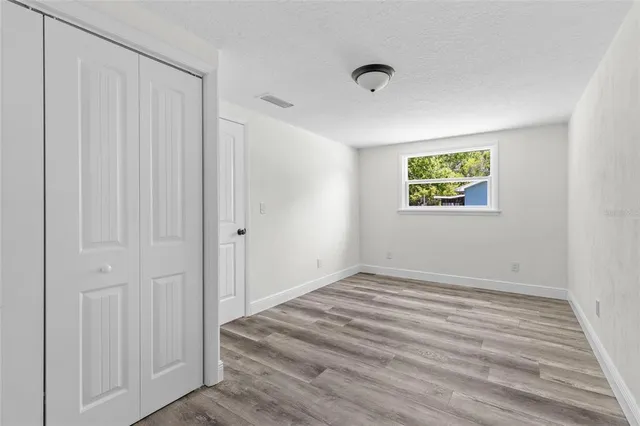 a view of a room with wooden floor and window