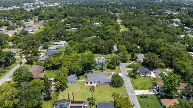 an aerial view of residential houses with outdoor space and trees