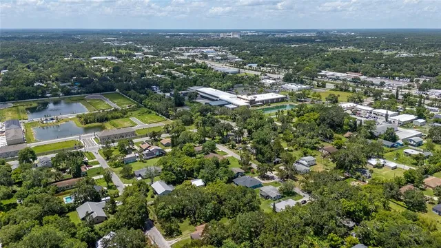 an aerial view of residential houses with outdoor space and trees