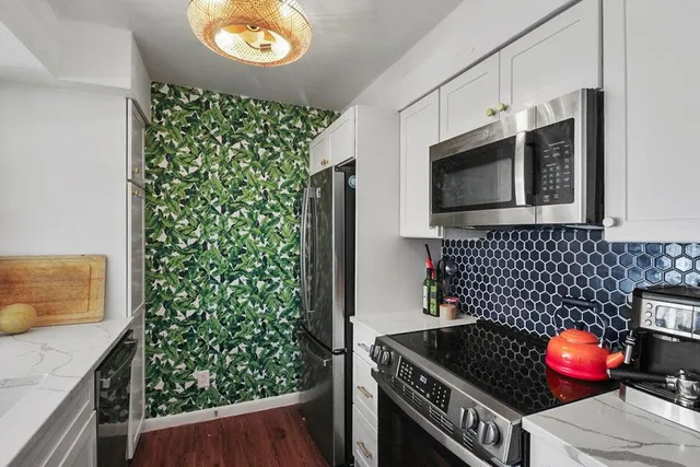 a kitchen with granite countertop a stove and a microwave